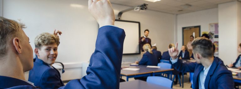 A teacher asks uniformed teenagers a question